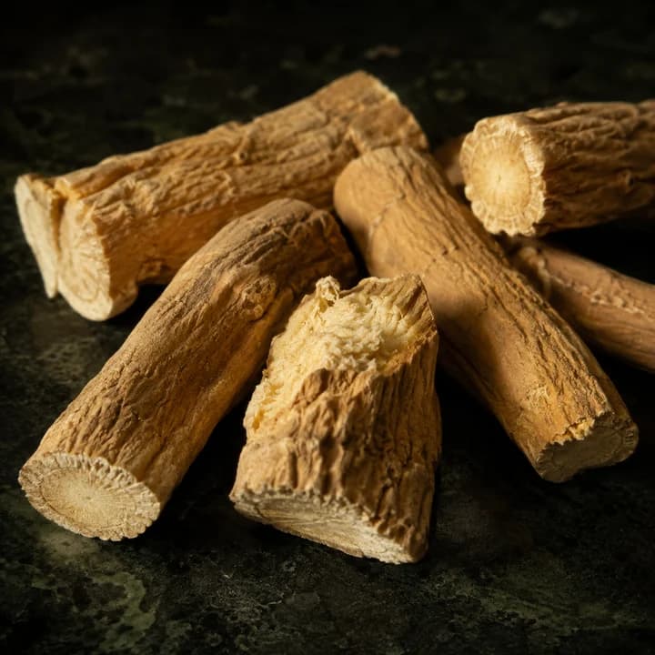 Dried pieces of ashwagandha root on dark stone