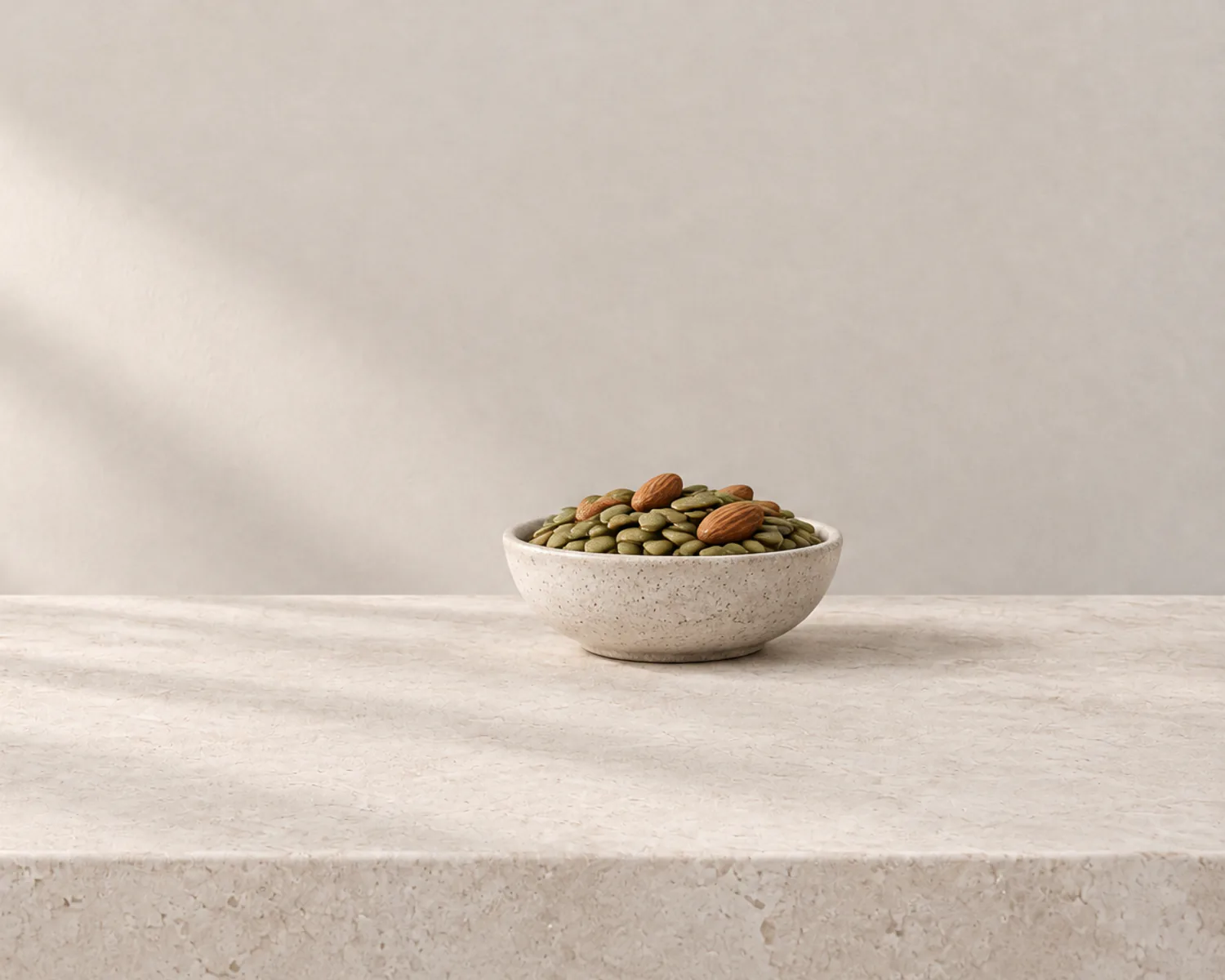 Pumpkin seeds and almonds in a stoneware bowl